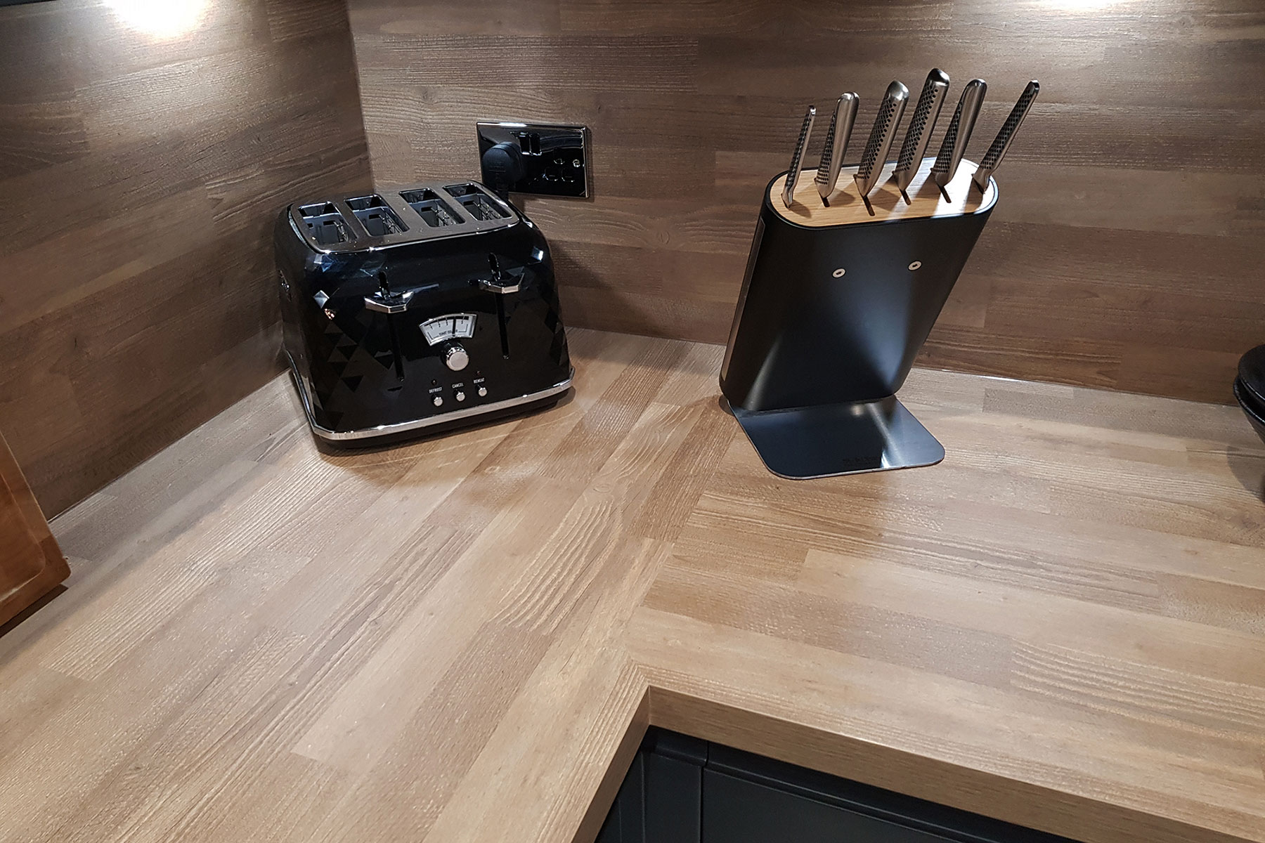Wood worktop with matching black style appliances in new fitted kitchen in congleton cheshire